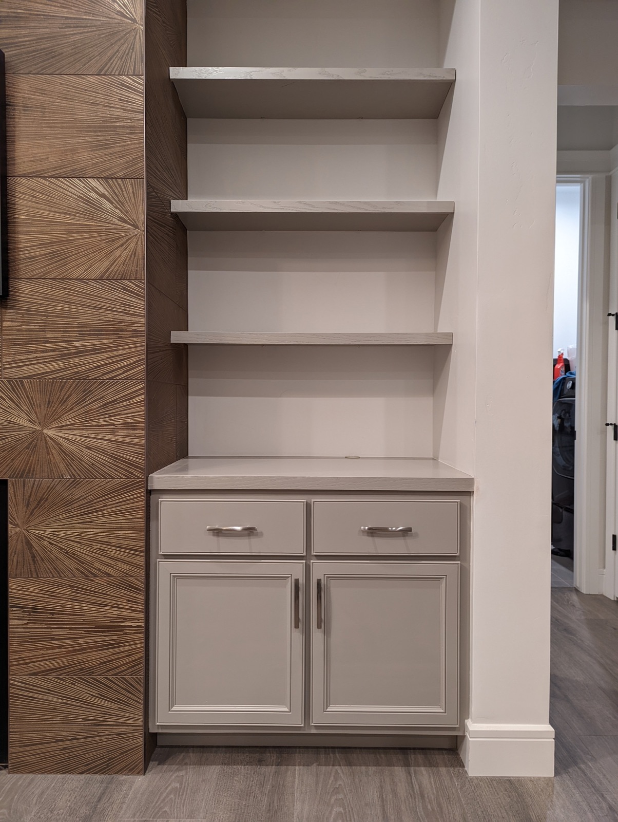 Cabinets and shelves being installed beside the fireplace