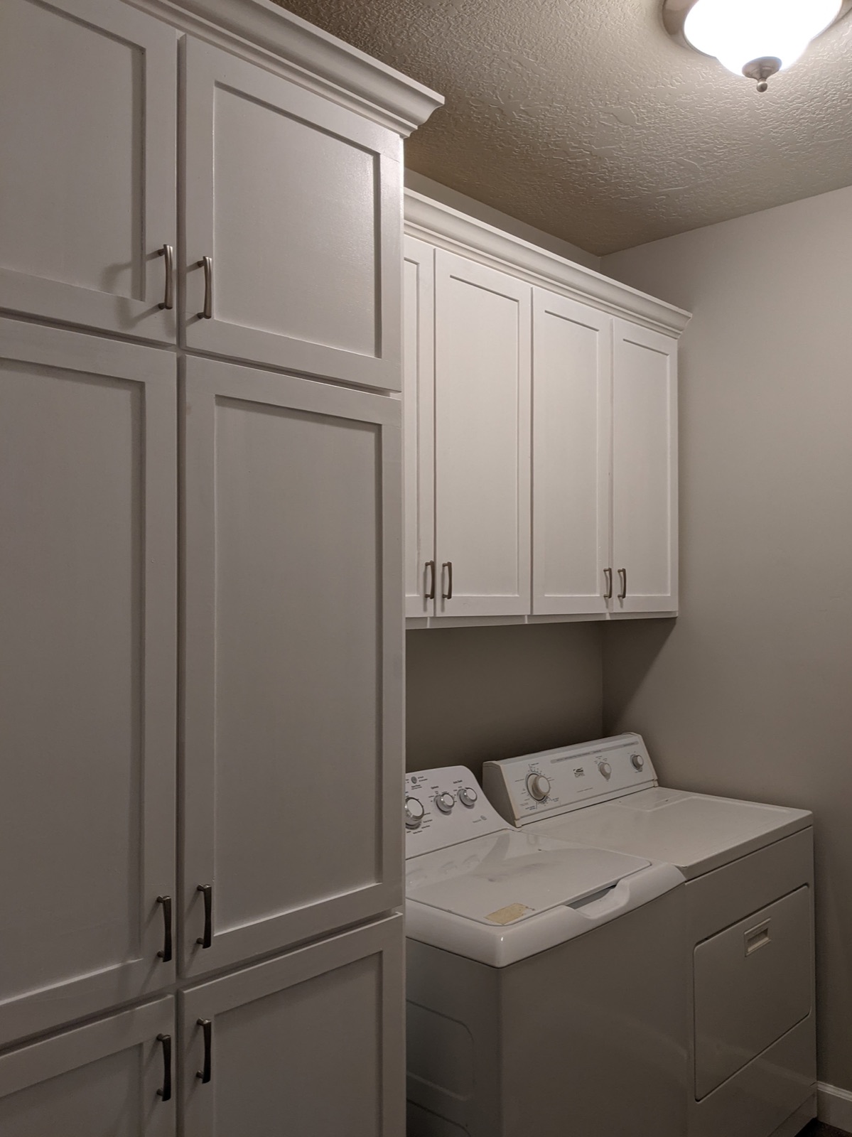 Finished laundry room wall and floor cabinets in white paint